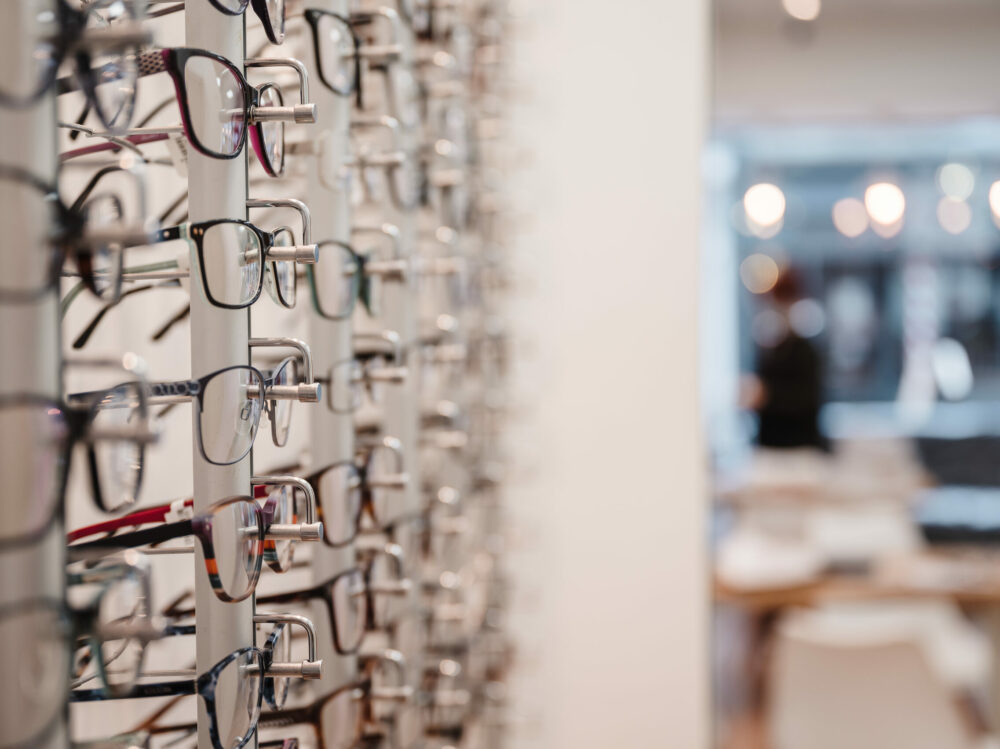 A selective focus shot of a row of glasses on display at an optics store